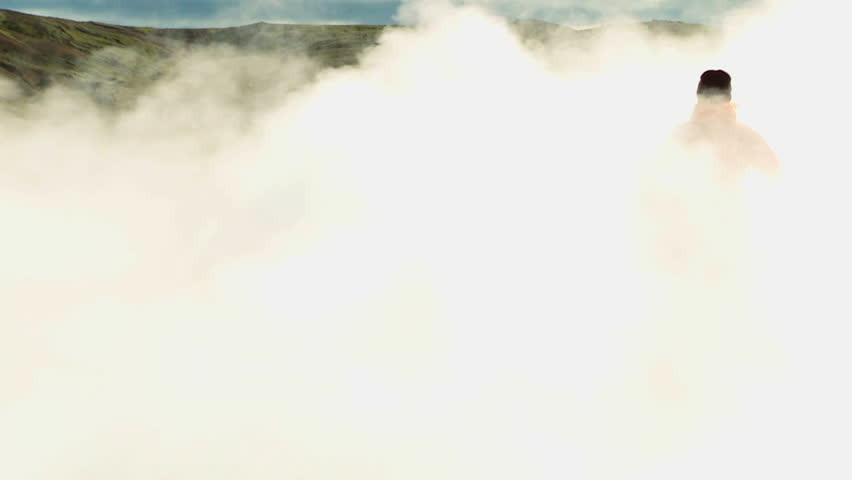 Female on Trekking Expedition Amongst Rising Volcanic Steam
