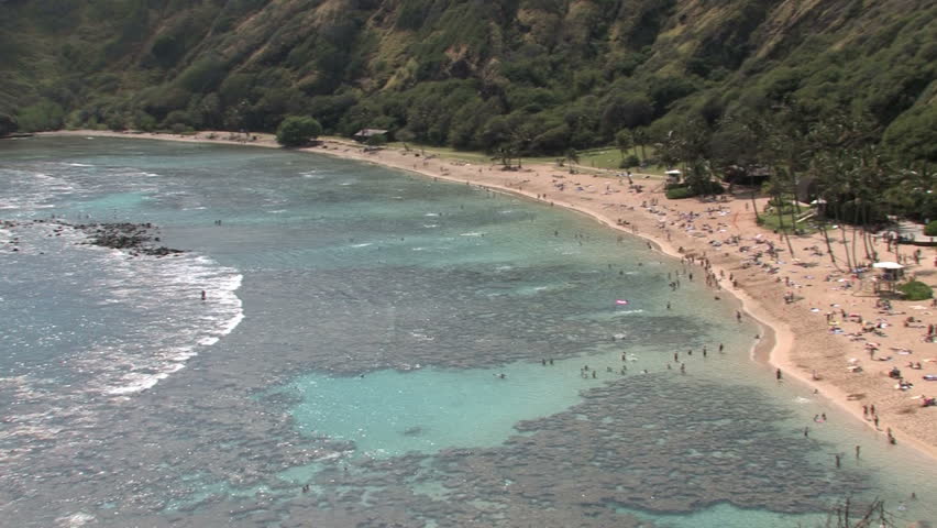 Hanauma Bay tropical beach on Oahu, Hawaii. Pan left. Coral area for swimming, snorkel and scuba. Scenic, relaxing, calm seascape. White sand beach.