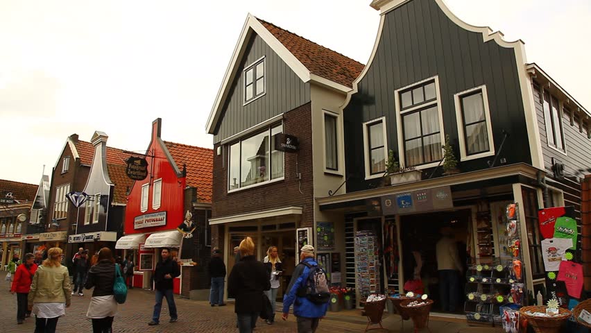 VOLENDAM - CIRCA APR 2011: Pedestrians walk down a cobblestone commercial street of a fishing village circa April 2011 in Volendam.
