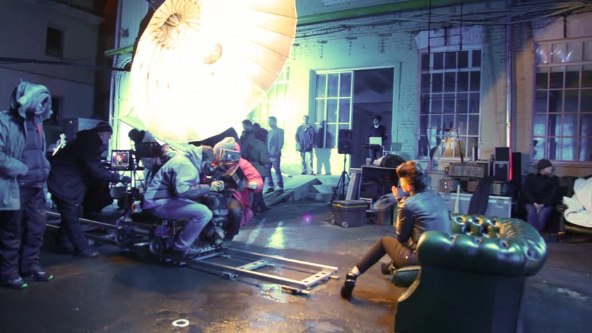 MOSCOW - OCTOBER 23: Rene sits in armchair in street under light of lamps and sings, operator with videocamera on rail cart keeps episode clips record on October 23, 2010 in Moscow, Russia. 