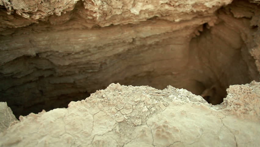 Medium wide slider dolly move over a crevice in the Ein Gedi desert at the foothills of Mount Masada in Israel.