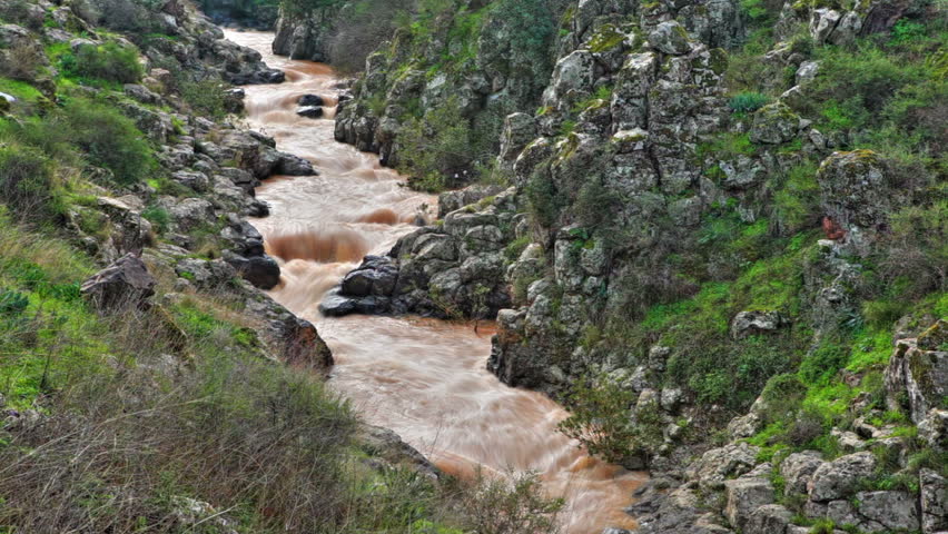 Medium wide shot of a winding river from the mountains of the Golan Heights in Israel.  