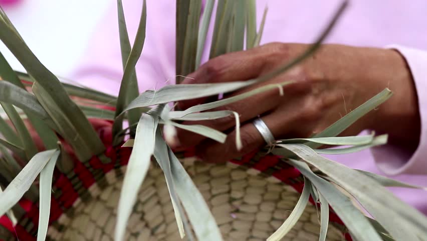 woman weaving a basket of palm