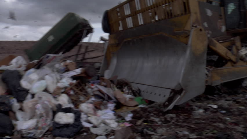 Bulldozer pushes trash at landfill