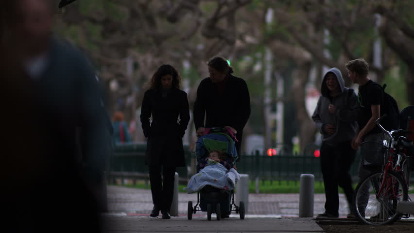 ISRAEL - FEB 2011: Israeli people pushing strollers at dusk in Tel Aviv Israel.  Shot with the Red One digital camera at 4k (4096 x 2304) resolution.  02/28/2011
