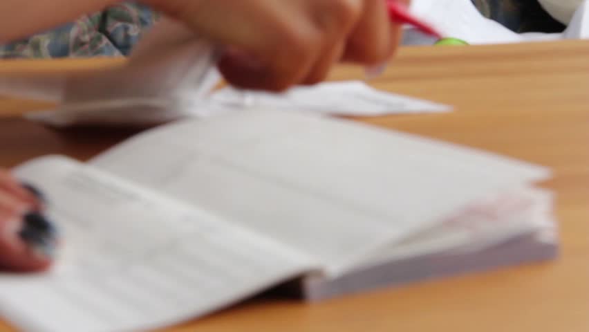 Woman writes notes on checkbook from receipts