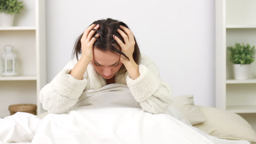 Sleepy woman waking up in bed
