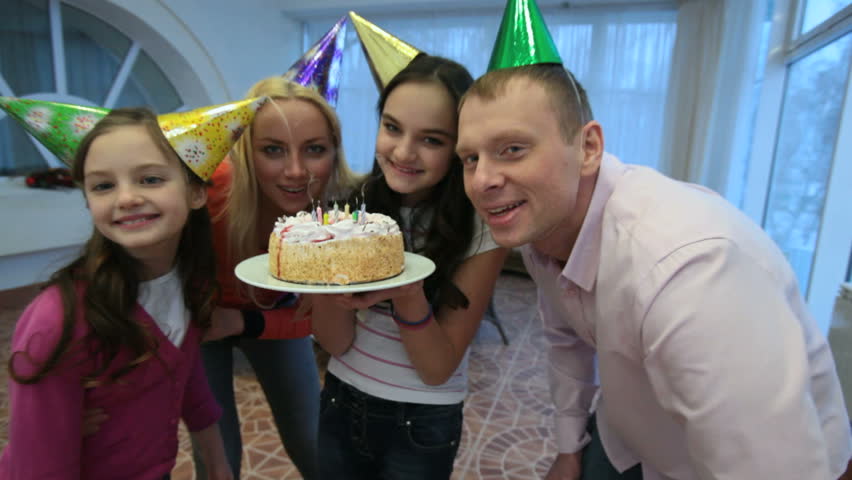 Family blowing candles together