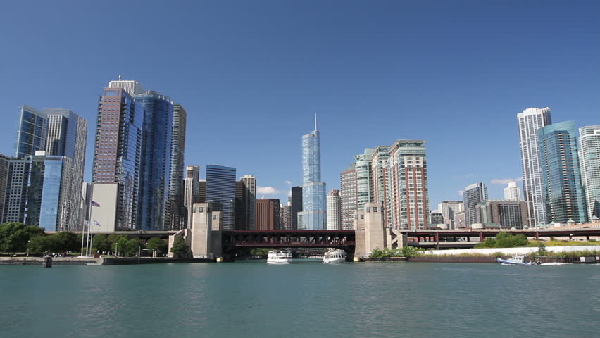 Smooth dolly shot of the Chicago skyline from the water, with boats entering and exiting the Chicago River