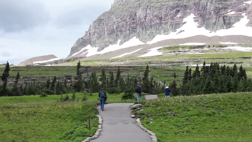 GLACIER NATIONAL PARK, MONTANA: AUG 10 2010 Father, son and family hike mountain trail for exercise and to explore for wildlife in Montana. Family activities important for growth of a happy family.