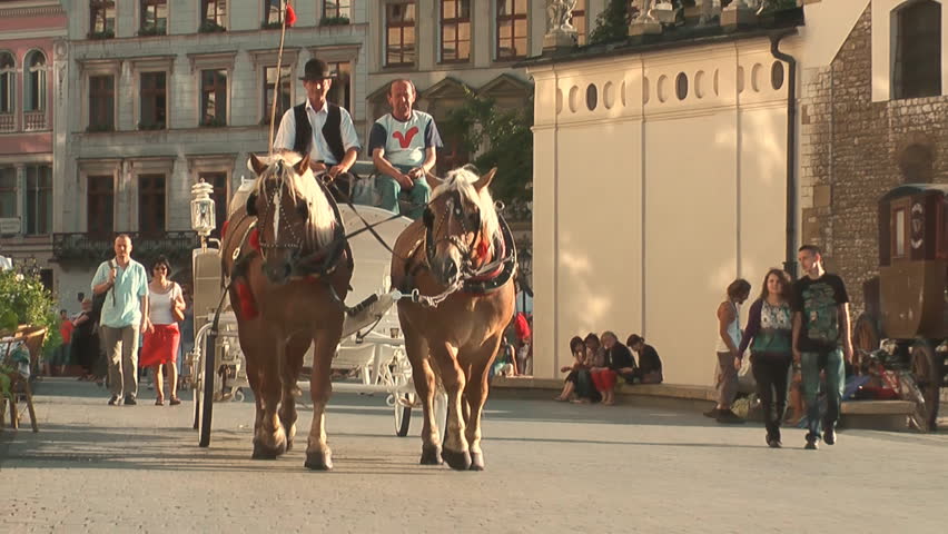 KRAKOW, POLAND - CIRCA 2011: Tourists take city tour on horse-drawn carriage.
