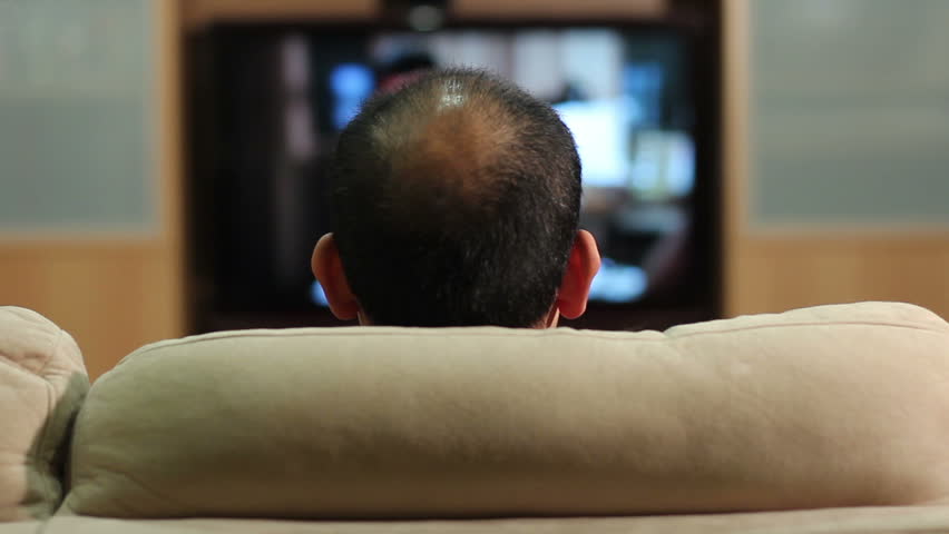 HD clip of a balding man watching an HDTV, turning it off and leaving.
