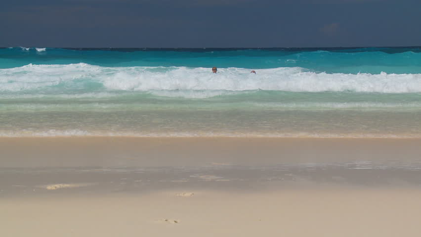 couple running into the waves
