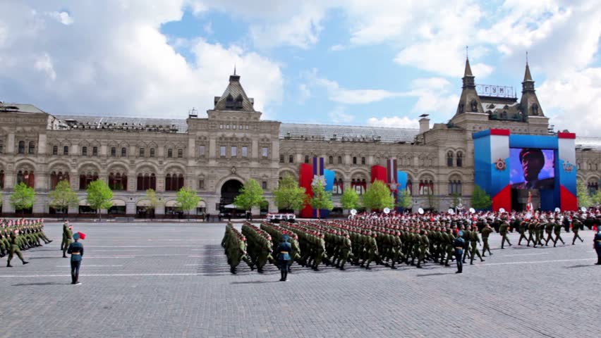 MOSCOW - MAY 9: Soldiers ranks march with guns on Red square on Victory Parade, little girl shown on video screen at GUM on May 9, 2011 in Moscow, Russia