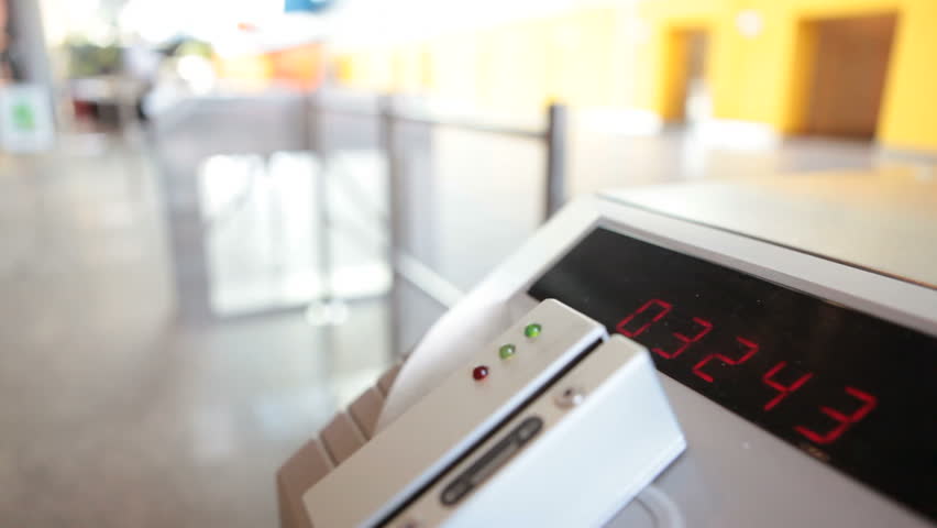 People sliding cards through card reader on office turnstile