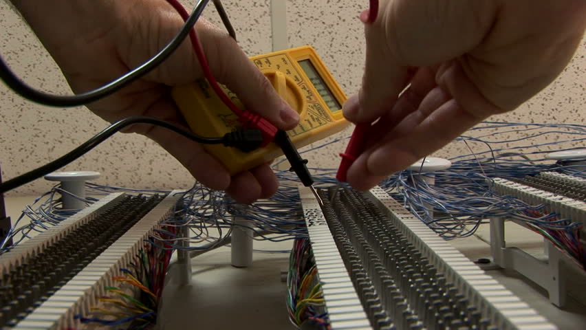 repairman checking voltages on a punch block