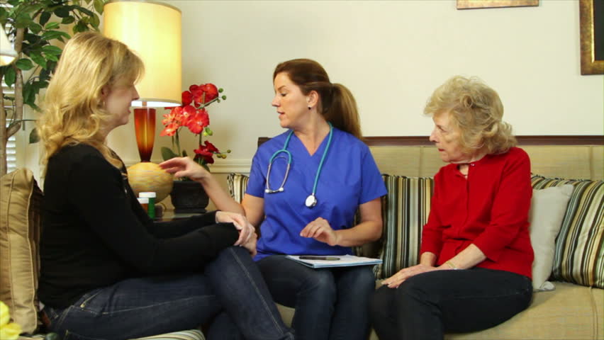 A pretty home health nurse instructs an elderly patient and her daughter on the prescribed medications.