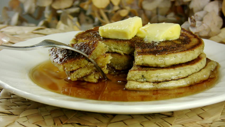 Eating Pancakes with Maple Syrup (HD). Eating a piece of a stack of pancakes with butter and Maple Syrup.