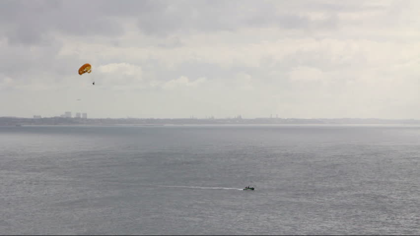 An extreme wide shot of a paraglider being towed by a speedboat, off the coast of Santa Monica, CA.
