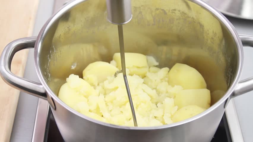 Cooked potatoes being mashed