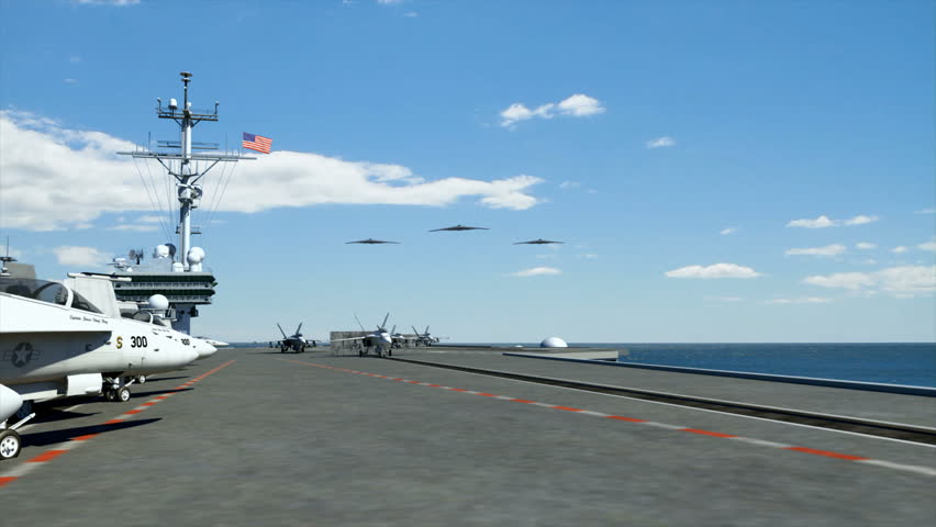 Three B-2 Stealth Bombers flying overhead as F18 Hornets take off from an American aircraft carrier in the Persian Gulf. 