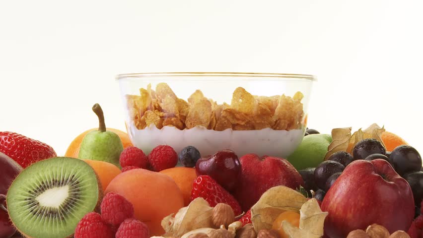 Fresh fruit and bowl of cornflakes, milk and berries