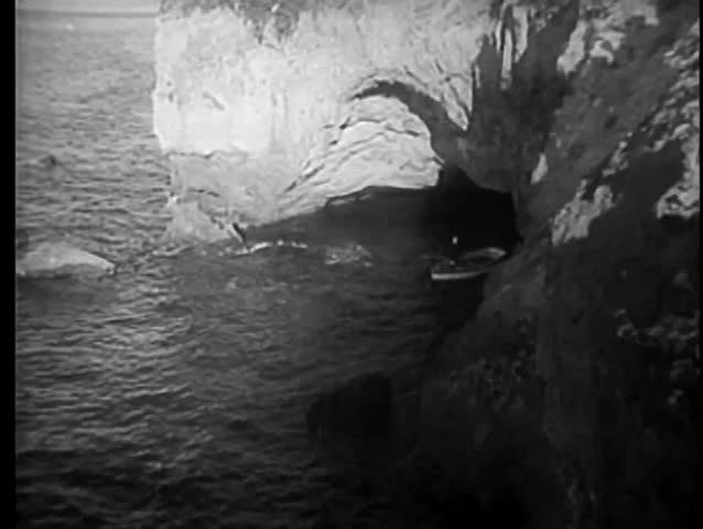 High angle view of row boat leaving grotto
