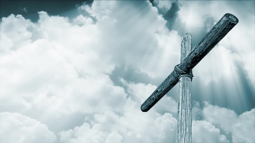 wooden cross backed by time lapse motion clouds with shining, penetrating shafts of light - cyan tone