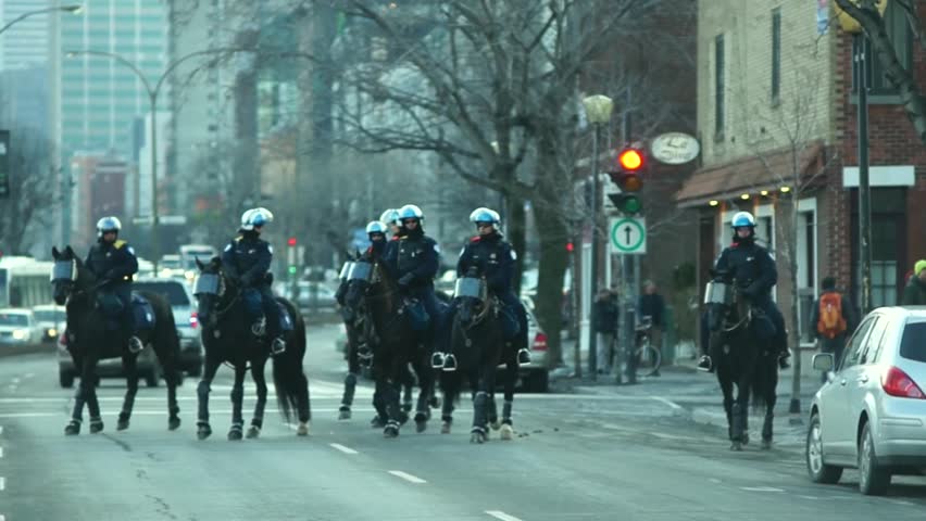 MONTREAL, CANADA - CIRCA FEBRUARY 2012 - Mounted police are police patrol on horseback during the protest against proposed tuition hikes in Quebec circa February 2012 in Montreal, Canada. Horses wear facial armor.