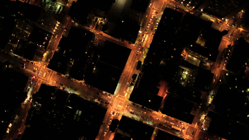 Aerial vertical view at night of city traffic illuminated by city streets and skyscrapers, North America, USA