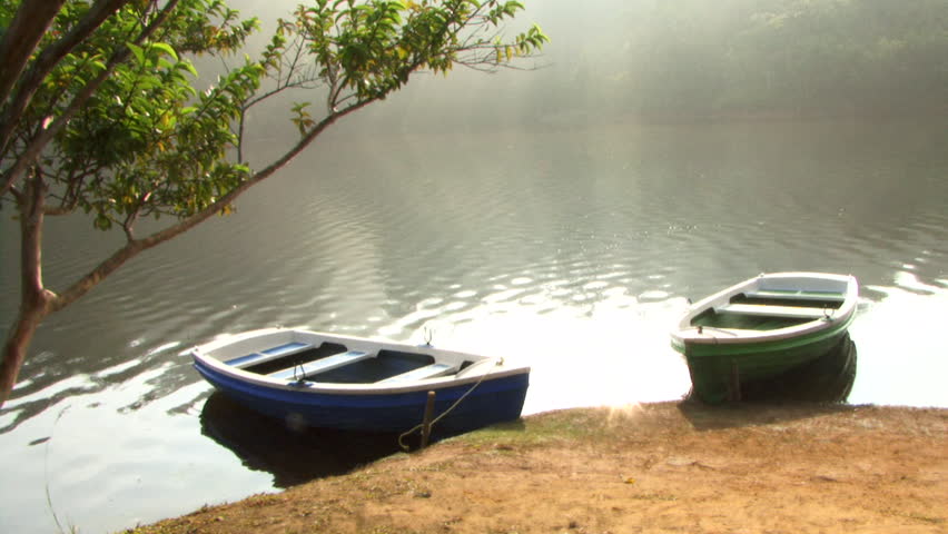 Two row boats docked at the edge of a river