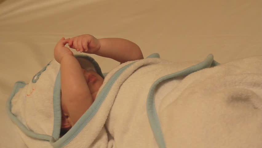 Relaxed baby in a towel after bath