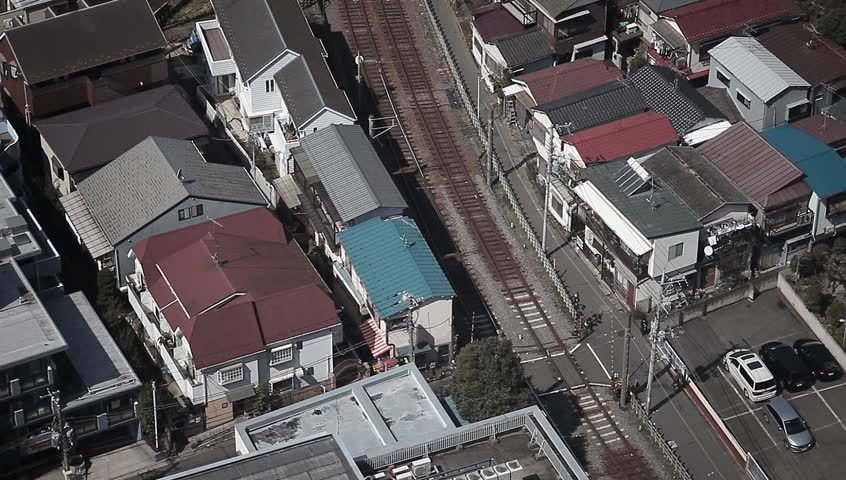 Aerial view of a train line running through a residential district in the outskirts of Tokyo, Japan