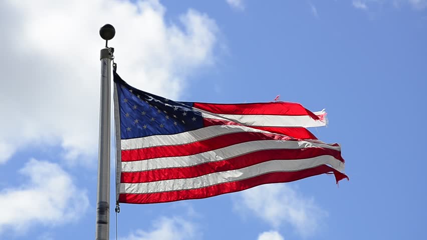 American Flag Blowing in the Wind with Blue Sky and Clouds in Background