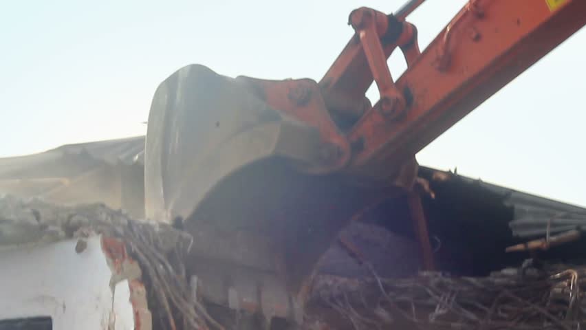 Building demolition, excavator and twisted rebars
