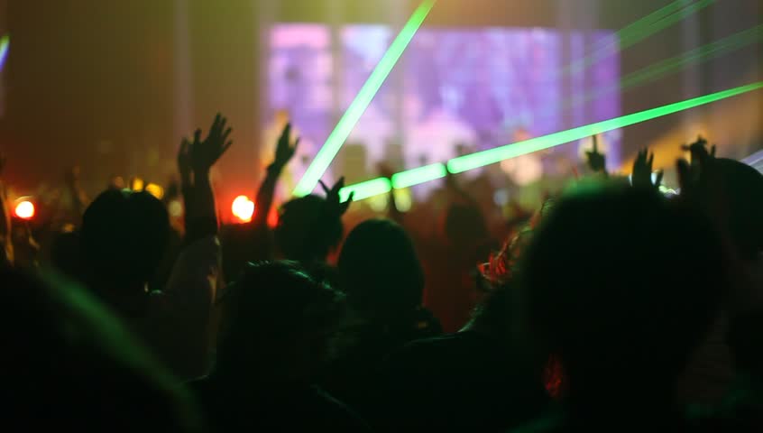 Crowd of people illuminated by colorful light during a concert