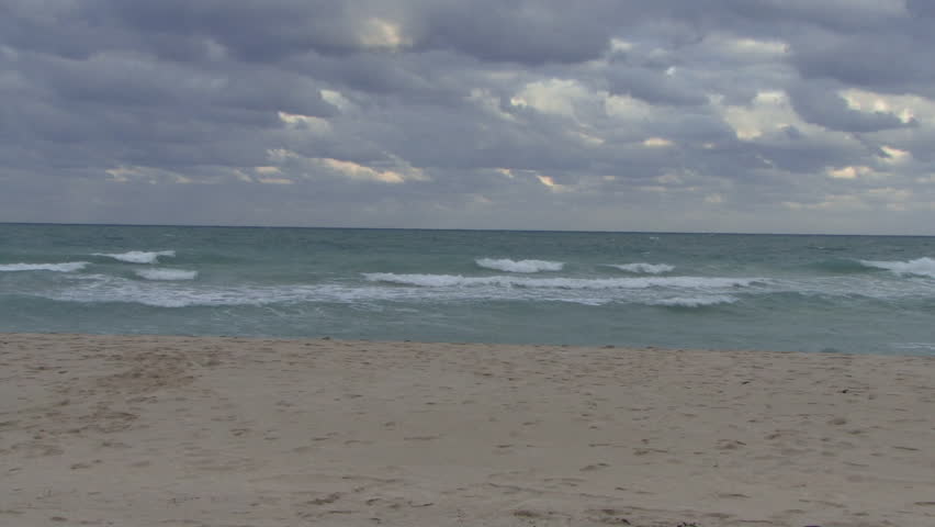 Male taking his suit off and running into an ocean