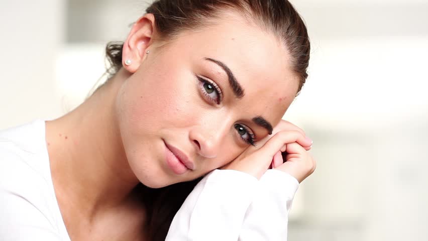 Happy young woman thinking positive thoughts smiling at camera