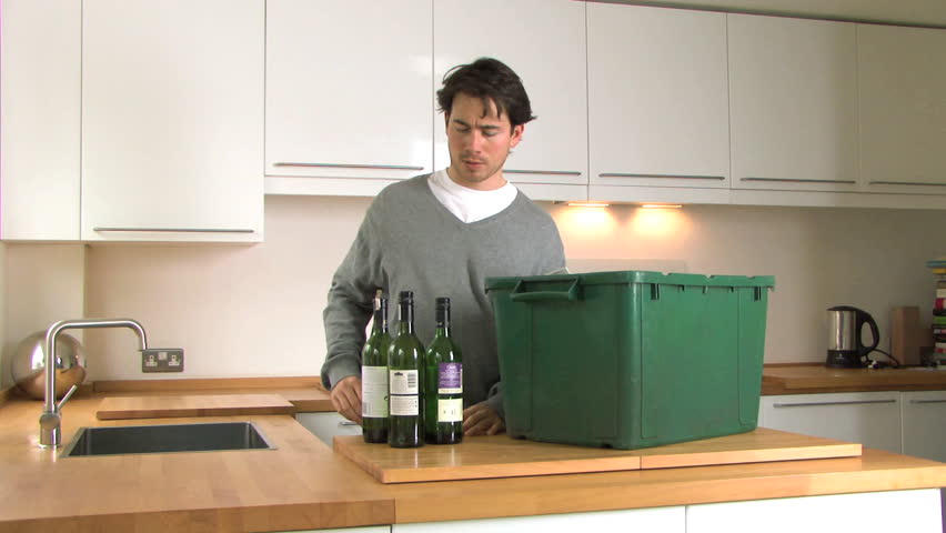 MEDIUM SHOT OF A MAN RECYCLING BOTTLES