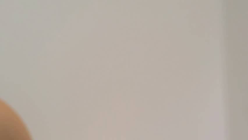 CLOSE UP PAN OF A YOUNG WOMAN MOISTURIZING HER FACE ON WHITE BACKGROUND