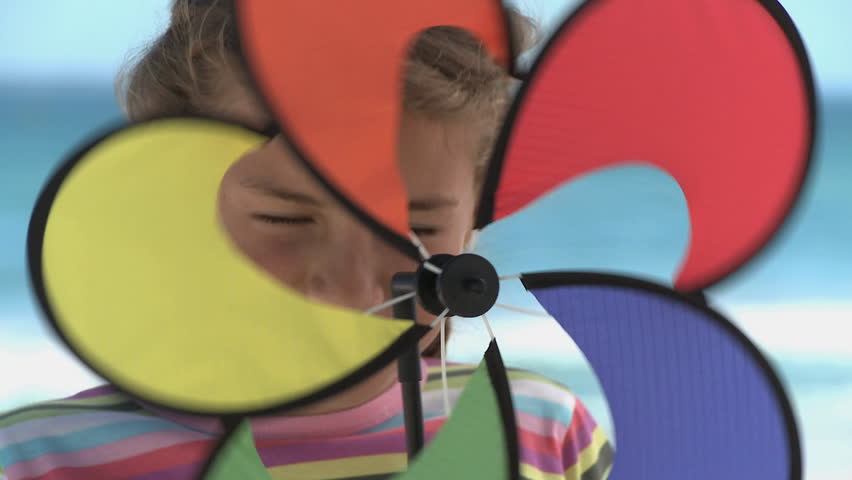 CLOSE UP OF A GIRL SPINNING A PIN WHEEL