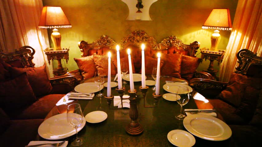 Candlestick decorates table in center and supplements east decor of restaurant