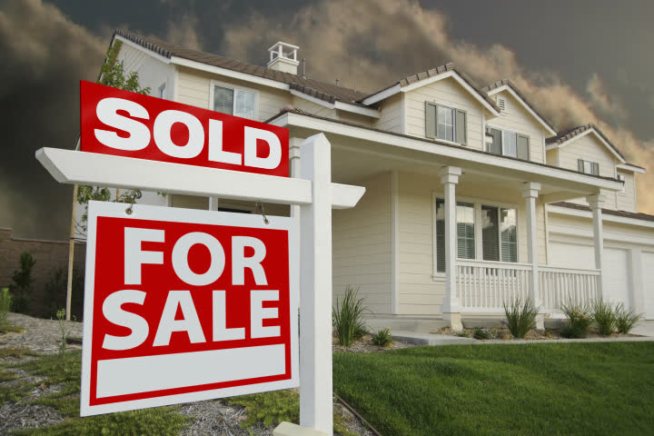 Sold Home For Sale Sign & New House with rapidly moving clouds in the background. The end of this clip contains a animated glow on the word "SOLD."