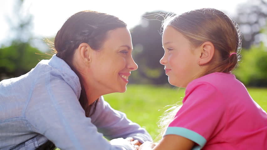 Mother and daughter rubbing their noses in the countryside