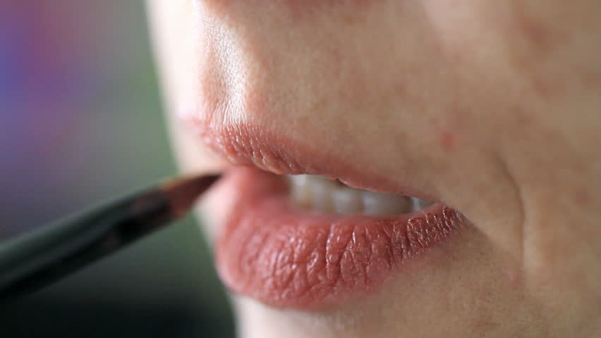 woman applying red lipstick gloss on lips