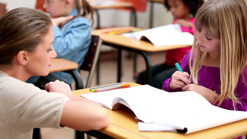Peaceful teacher helping a pupil in the classroom