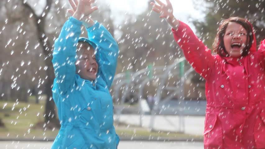 Cheerful kids enjoying summer sun-shower