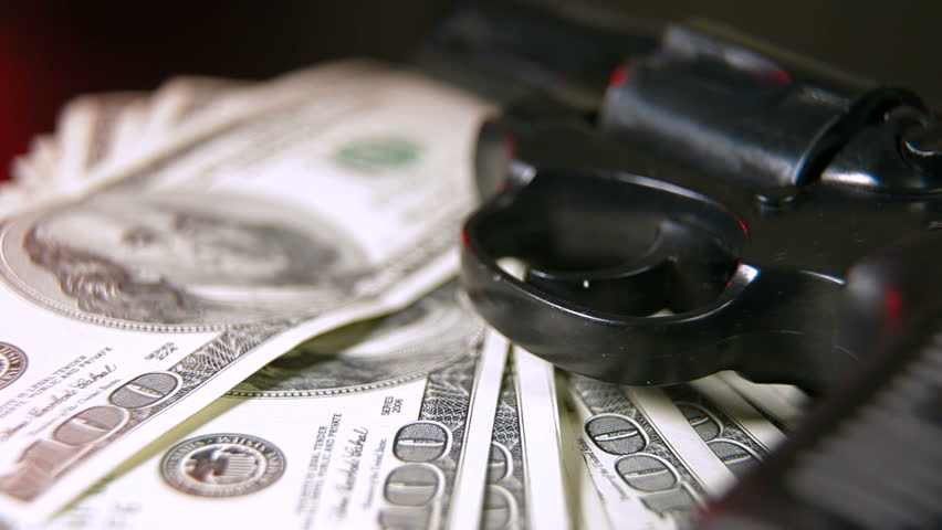 Gun and Cash Illuminated By Red Flashing Light