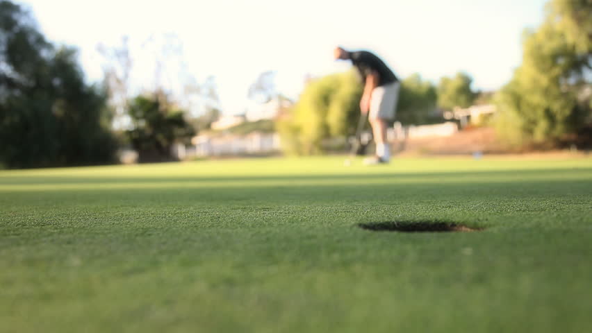 Golf ball coming towards the camera but just missing the putt