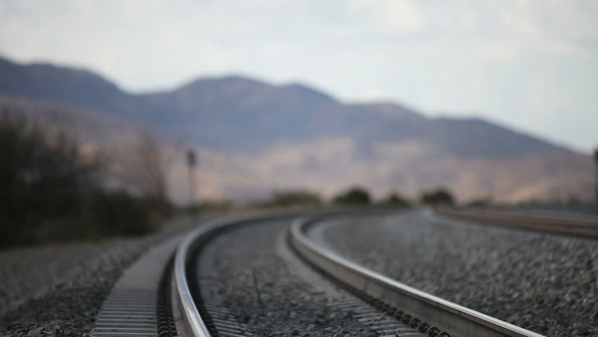 Young runaway walking down the railroad tracks
